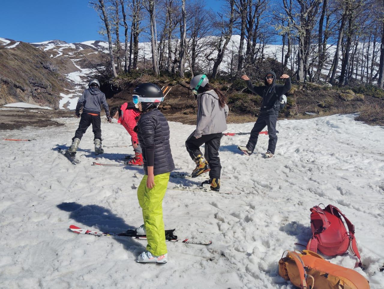Clase de esquí con niños y adolescentes en la nieve, guiada por un instructor