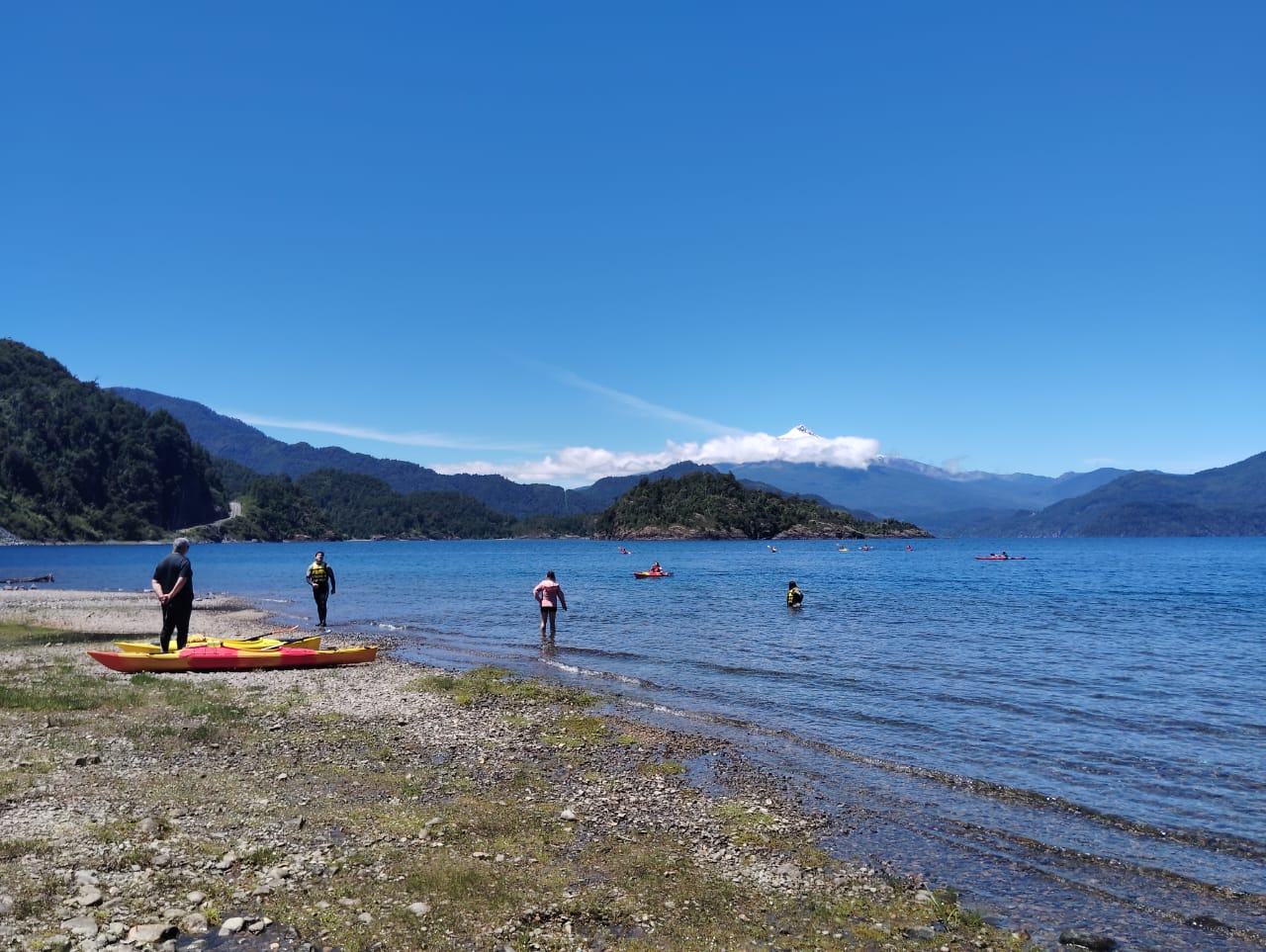 Jornada de kayak en el lago con niños en el agua y en la orilla