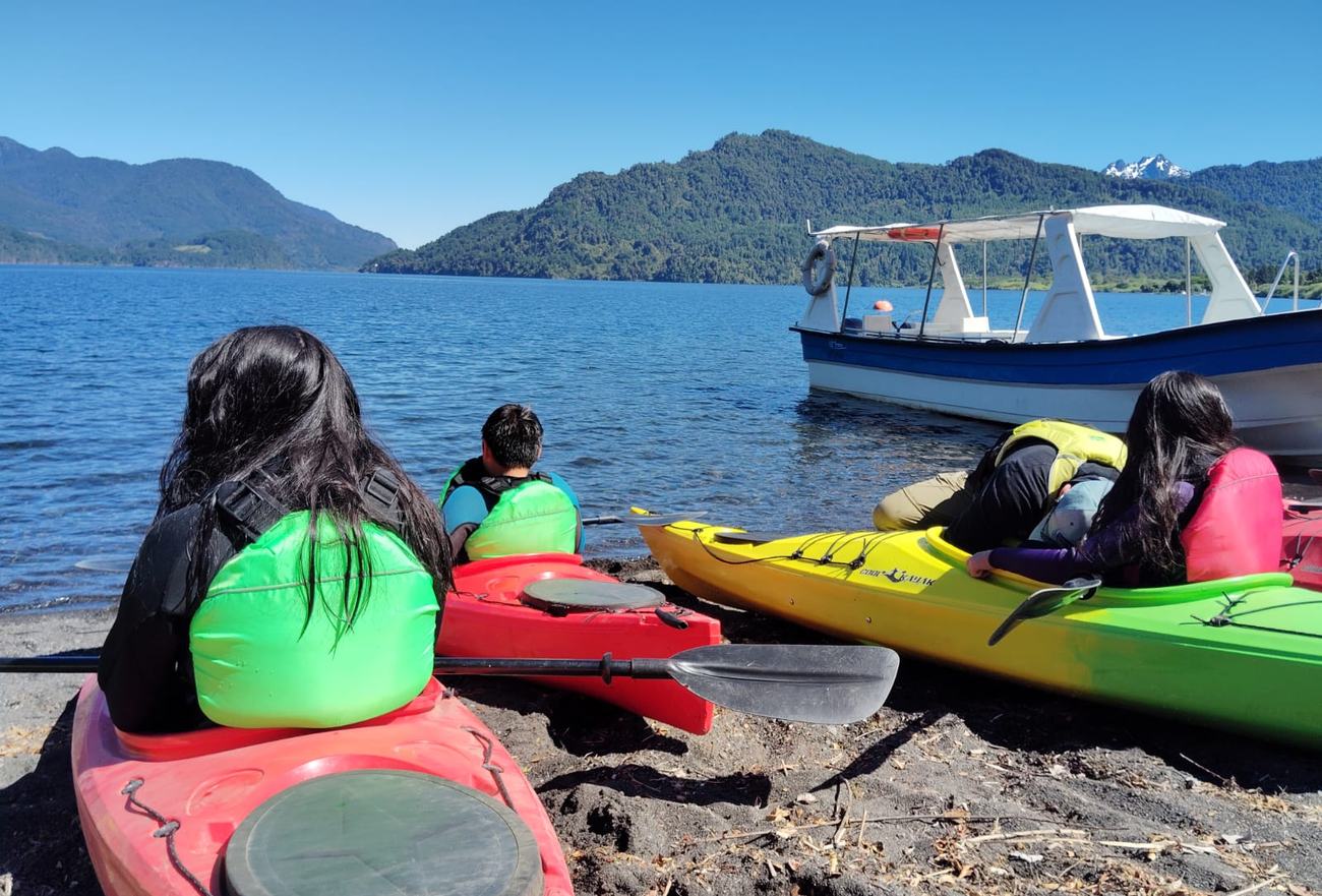 Niños preparándose en sus kayaks a orillas del lago