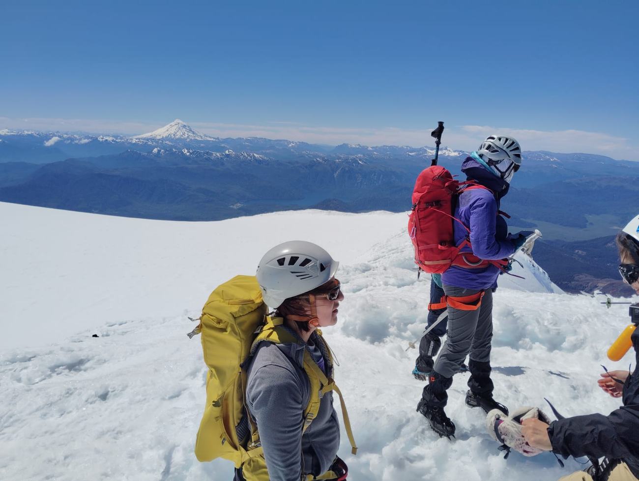 Cordada en la cumbre con el volcán Lanín y los lagos al fondo